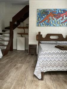 a bedroom with a bed and a painting on the wall at Pousada Familia Quandt in Guarda do Embaú