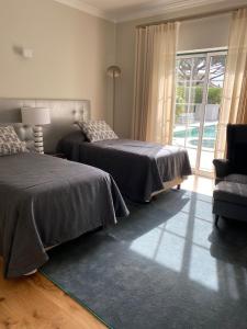 a bedroom with two beds and a chair and a window at Charming Exceptional Golf Villa in Algarve in Faro