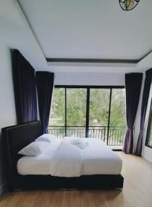 um quarto com uma cama e uma janela grande em Parada Ayutthaya 