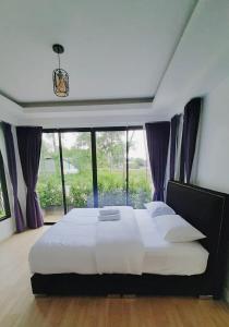 um quarto com uma cama grande e uma janela grande em Parada Ayutthaya 