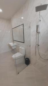 a white bathroom with a toilet and a shower at Parada Ayutthaya in Pak Kran