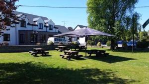 a picnic area with picnic tables and an umbrella at Balreask Bar, Restaurant & Guest Accommodation in Navan