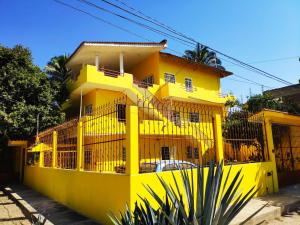 a yellow building with a fence in front of it at Habitación Hansa in Puerto Vallarta