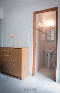 a bathroom with a sink and a toilet and a mirror at Hostel El Español in Colonia del Sacramento