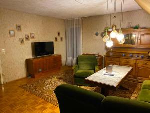 ディリンゲン・アン・デア・ドナウにあるFerienwohnungen / Ferienhaus Dillingen an der Donauのソファとテーブルとテレビのあるリビングルーム
