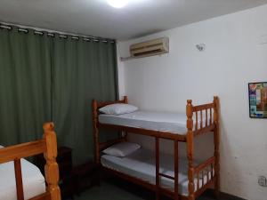 Cette chambre comprend 2 lits superposés et un ventilateur. dans l'établissement Pousada Pedra do Sol, à Parati