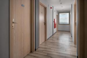 a corridor of an office with wooden floors and doors at Dom Żeglarza in Puck