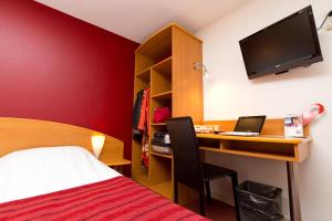 a bedroom with a desk with a computer and a bed at Prest'Hôtel Epinal in Épinal