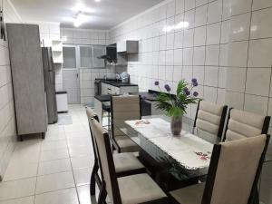a dining room with a table and chairs and a kitchen at Casa Walter in Balneário Camboriú