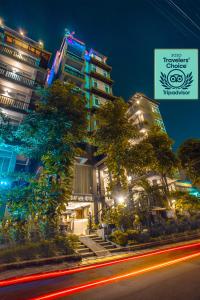 a building with trees in front of a street at King Grand Boutique Hotel in Phnom Penh