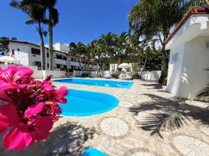 a view of a swimming pool with palm trees at Residencial Hostal Blanco in Florianópolis