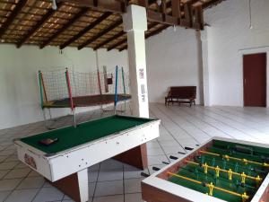duas mesas de bilhar numa sala com uma bola de voleibol em Residencial Hostal Blanco em Florianópolis