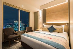 a hotel room with a bed and a window at Hotel Metropolitan Tokyo Marunouchi in Tokyo