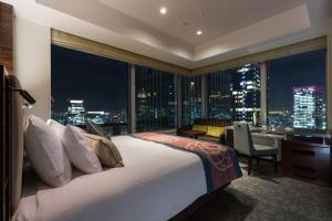 a hotel room with a bed and a large window at Hotel Metropolitan Tokyo Marunouchi in Tokyo