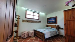 a small bedroom with a bed and a window at El Quijote Apartahotel in Jericó