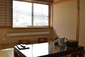 Tōno的住宿－Takamuro Suikoen，一间带桌子和窗户的用餐室