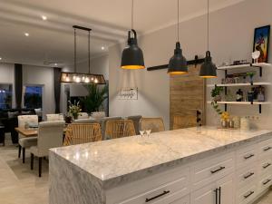 a kitchen with a large counter and a dining room at Beachfront Rice Field View Lovina Villa Serenity Bali in Pengastulan