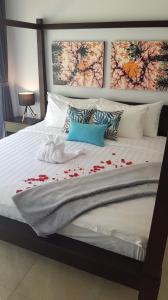 Una cama grande con rosas rojas. en Beachfront Rice Field View Lovina Villa Serenity Bali, en Pengastulan