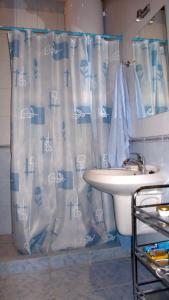 ein Bad mit einem Duschvorhang und einem Waschbecken in der Unterkunft Guest House Orlinoe - Sevastopol in Orlinoye