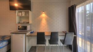 a kitchen with a counter with chairs and a microwave at Paruna Motel in Swan Hill