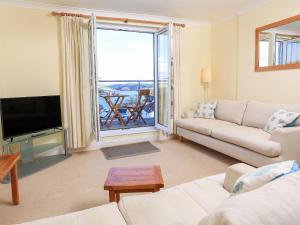 a living room with a couch and a television at 4 Lyndhurst in Salcombe