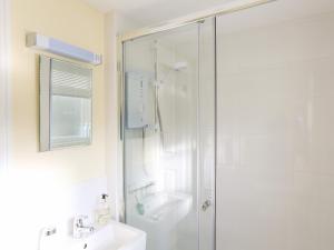 a white bathroom with a shower and a sink at 4 Lyndhurst in Salcombe +23 photos