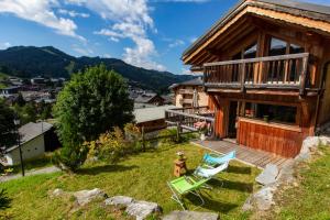 a house with a deck and two chairs on the yard at Le Grand Canyon in Les Gets