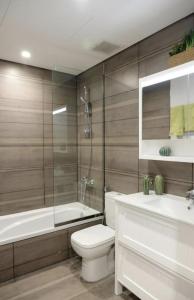 a bathroom with a toilet and a tub and a sink at Eden Residence in Jeddah