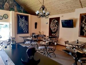 uma sala de jantar com mesas e cadeiras e um lustre em Ipe Tombe Guest Lodge - Midrand em Midrand