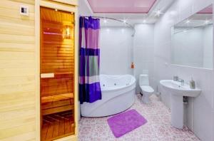 a bathroom with a tub and a toilet and a sink at InnHome Apartments in Chelyabinsk