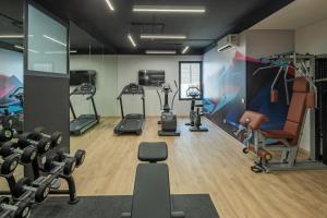une salle de sport avec plusieurs tapis de course et équipements d'exercice dans l'établissement Eden Residence, à Djeddah