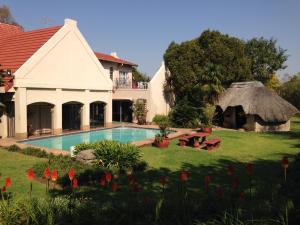 a house with a swimming pool in the yard at Ipe Tombe Guest Lodge in Midrand