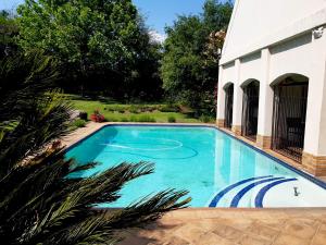 uma piscina em frente a uma casa em Ipe Tombe Guest Lodge - Midrand em Midrand