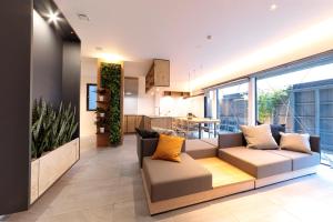 a living room with a couch and a kitchen at Condominium ISHITEI Furano in Furano