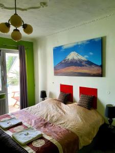 a bedroom with a bed with a mountain painting on the wall at StayInCologne in Cologne