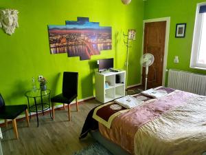 een groene slaapkamer met een bed en een tafel en stoelen bij StayInCologne in Keulen