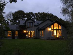 a house with its lights on in the night at The Vandees in Aghalee