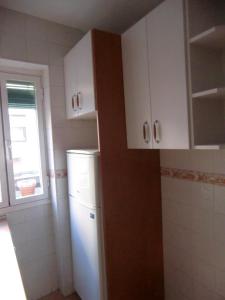 une cuisine avec un réfrigérateur blanc et une fenêtre dans l'établissement M17 Madrid Centro apartamento con wifi, à Madrid