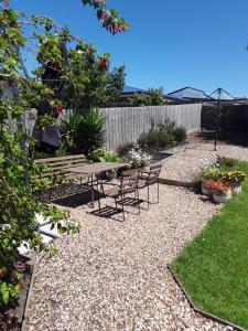 a patio with a table and chairs in a garden at Bay Bell Cottage in Saint Leonards