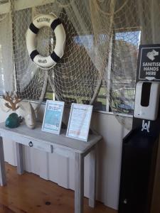 a table in a room with a window and a life preserver at Bay Bell Cottage in Saint Leonards