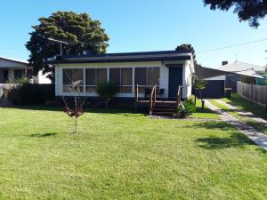 a house with a small tree in the yard at Bay Bell Cottage in Saint Leonards