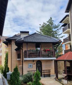 un edificio de ladrillo con un balcón con flores. en Vila D&D en Zlatibor