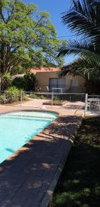 a swimming pool with a fence next to a house at Spandau Manor in Graaff-Reinet