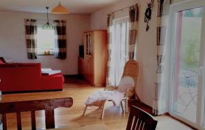 a living room with a dog sitting on a chair at Ferienhaus Rosenberg in Jandelsbrunn