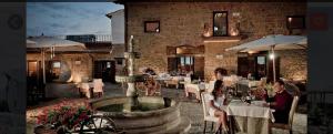 un par de mujeres sentadas en un restaurante con una fuente en Il Borgo Ariccia Resort, en Ariccia