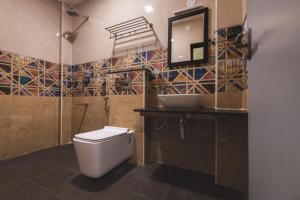 a bathroom with a toilet and a sink and a mirror at SKM REGENCY in Chennai