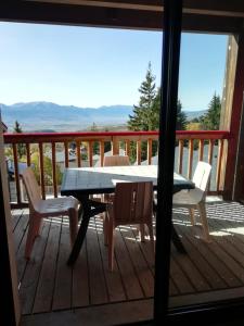 - une table et des chaises sur une terrasse avec vue dans l'établissement Font-Romeu près des pistes - Appartement 2 pièces très lumineux avec terrasse et vue panoramique, à Font-Romeu-Odeillo-Via