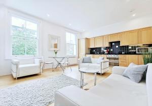 salon z białymi meblami i kuchnią w obiekcie Eden Luxury Apartments w Londynie