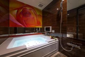 a bath tub in a bathroom with a shower at HOTEL ZEN Yokohama Hazawa in Yokohama