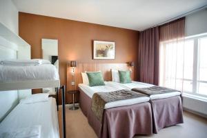 een hotelkamer met 2 bedden en een raam bij Skara Konsthotell in Skara